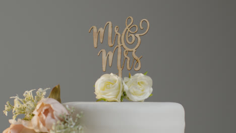 Close-Up-Of-Wedding-Cake-Against-Grey-Studio-Background-At-Wedding-Reception